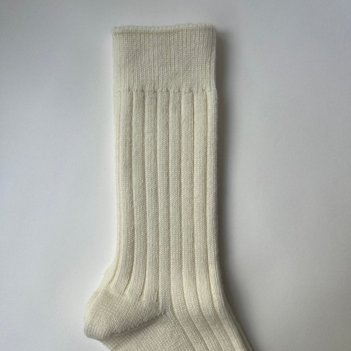 A pair of cream, ribbed, thickly knit merino socks. Made in Italy