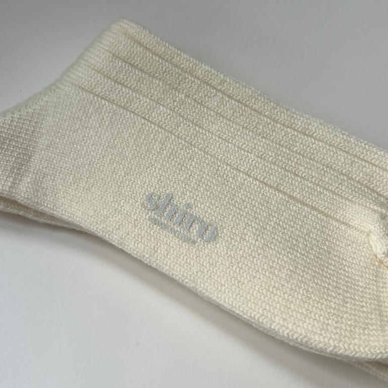 A pair of cream, ribbed, thickly knit merino socks. Made in Italy